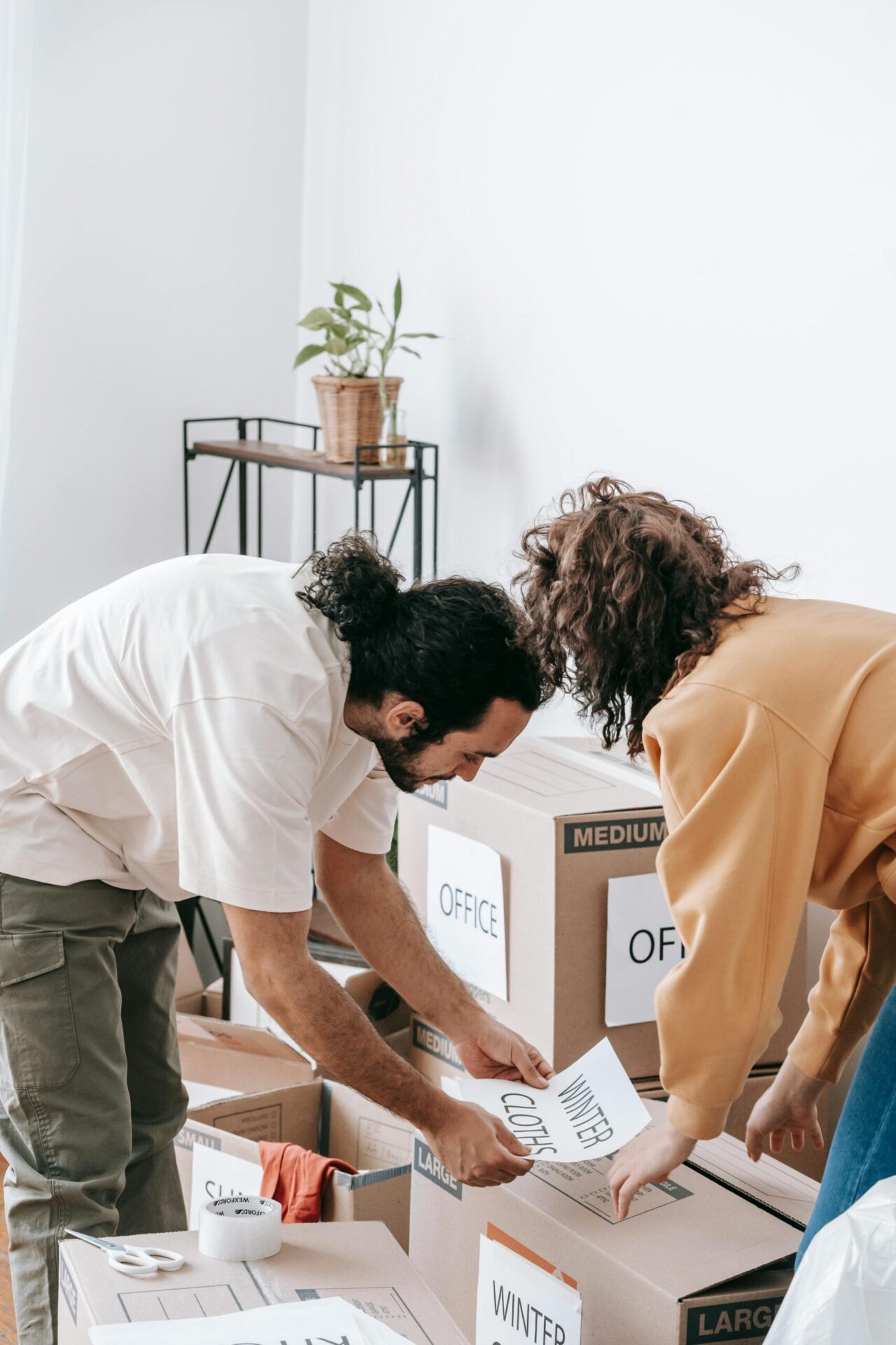 Couple organizes and labels boxes while preparing to move out of their apartment.
